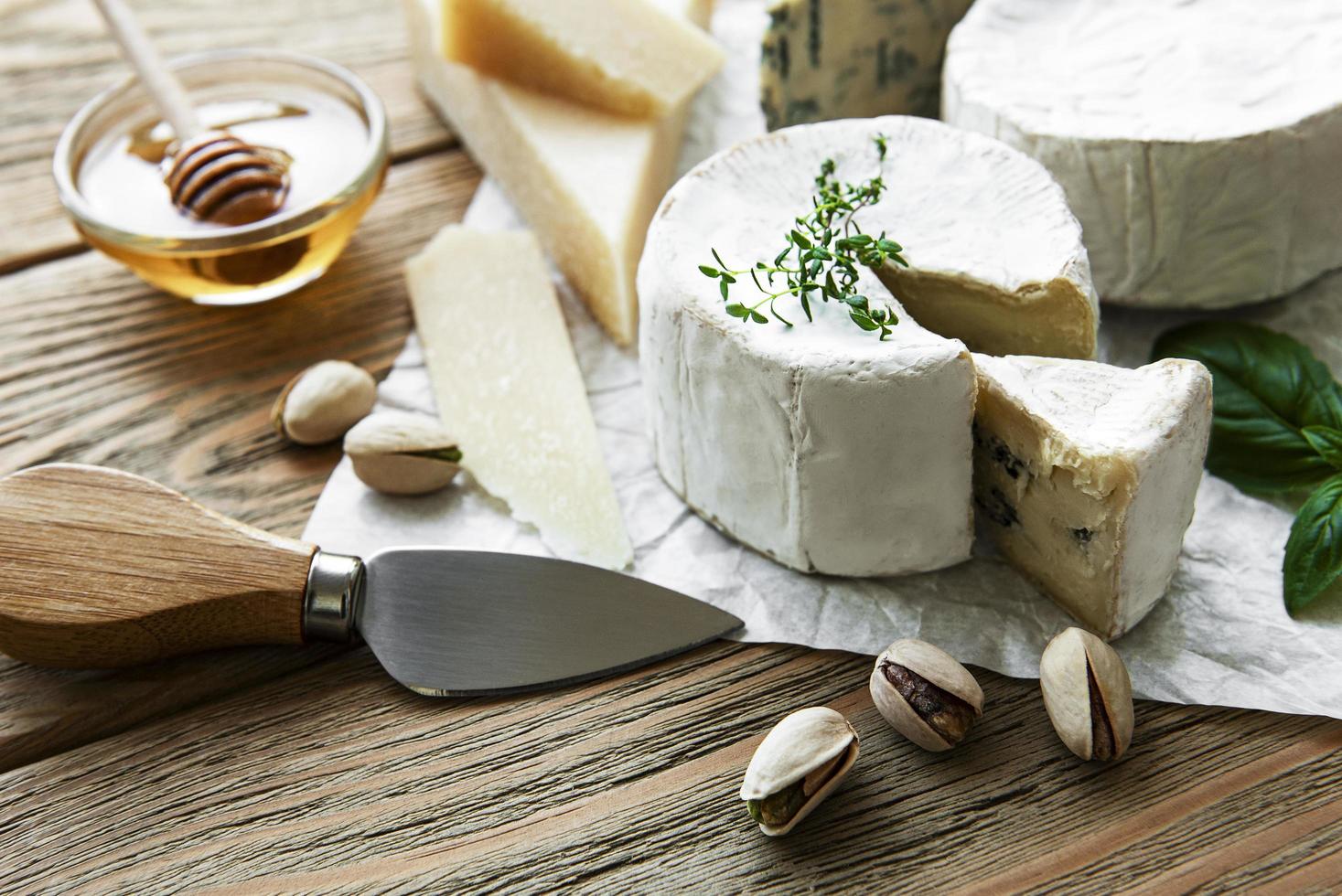 olika typer av ost, ädelost, bris och camembert på ett träbord foto