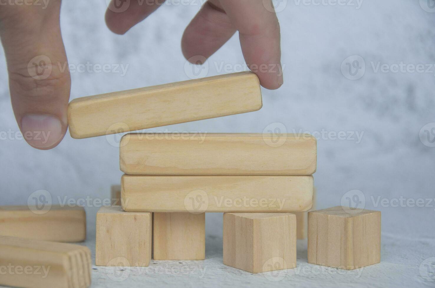 hand placering trä- blockera på topp av Övrig staplade trä- blockera med anpassningsbar Plats för text. kopia Plats. foto