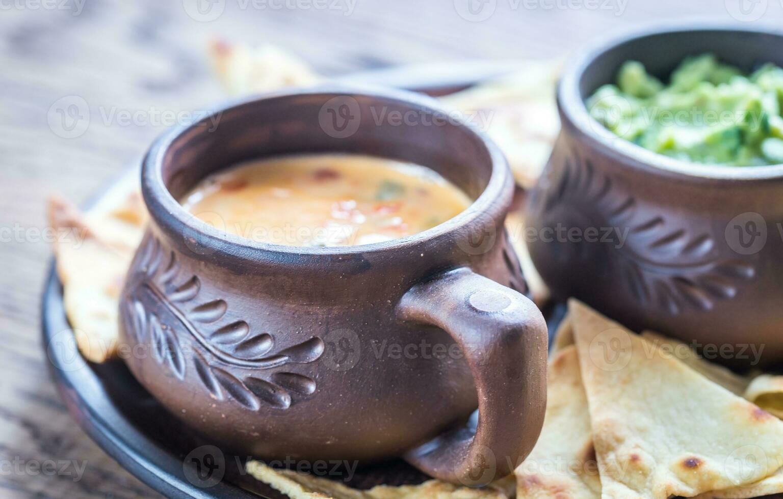 skålar med guacamole och queso med tortillachips foto