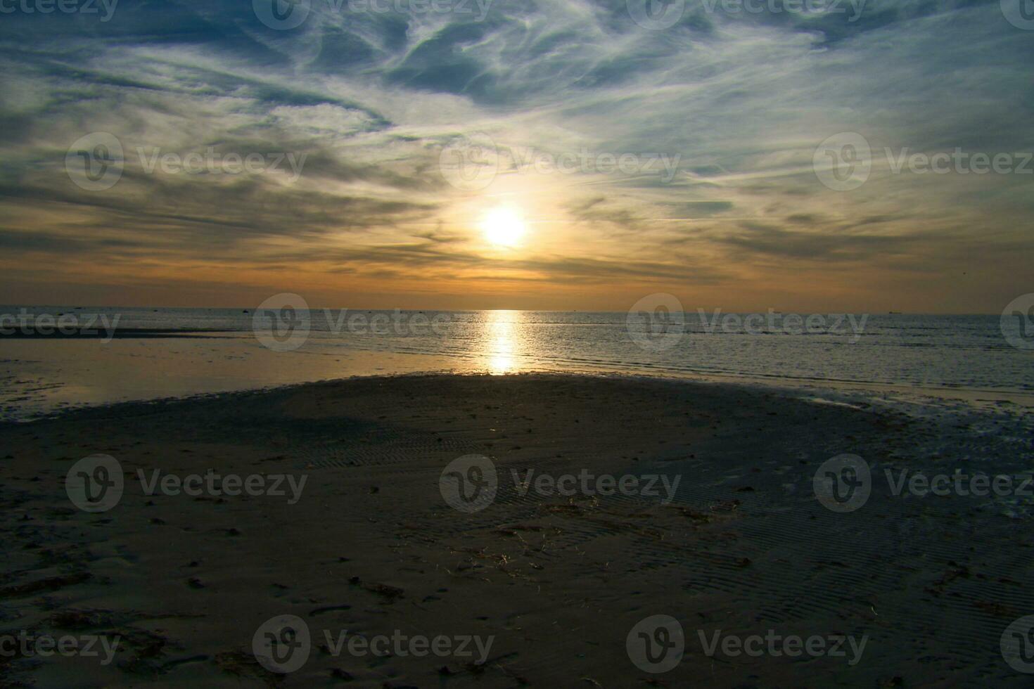 solnedgång, se över de sandig strand till de upplyst hav. ljus vågor. baltic hav foto