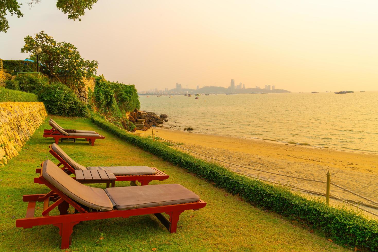 strandstolar med en strandhavsbakgrund vid solnedgången i Pattaya, Thailand foto