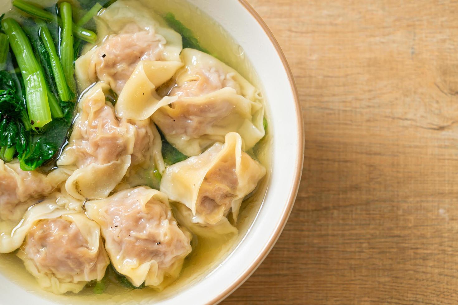 fläsk wonton soppa eller fläsk dumplings soppa med grönsaker - asiatisk matstil foto