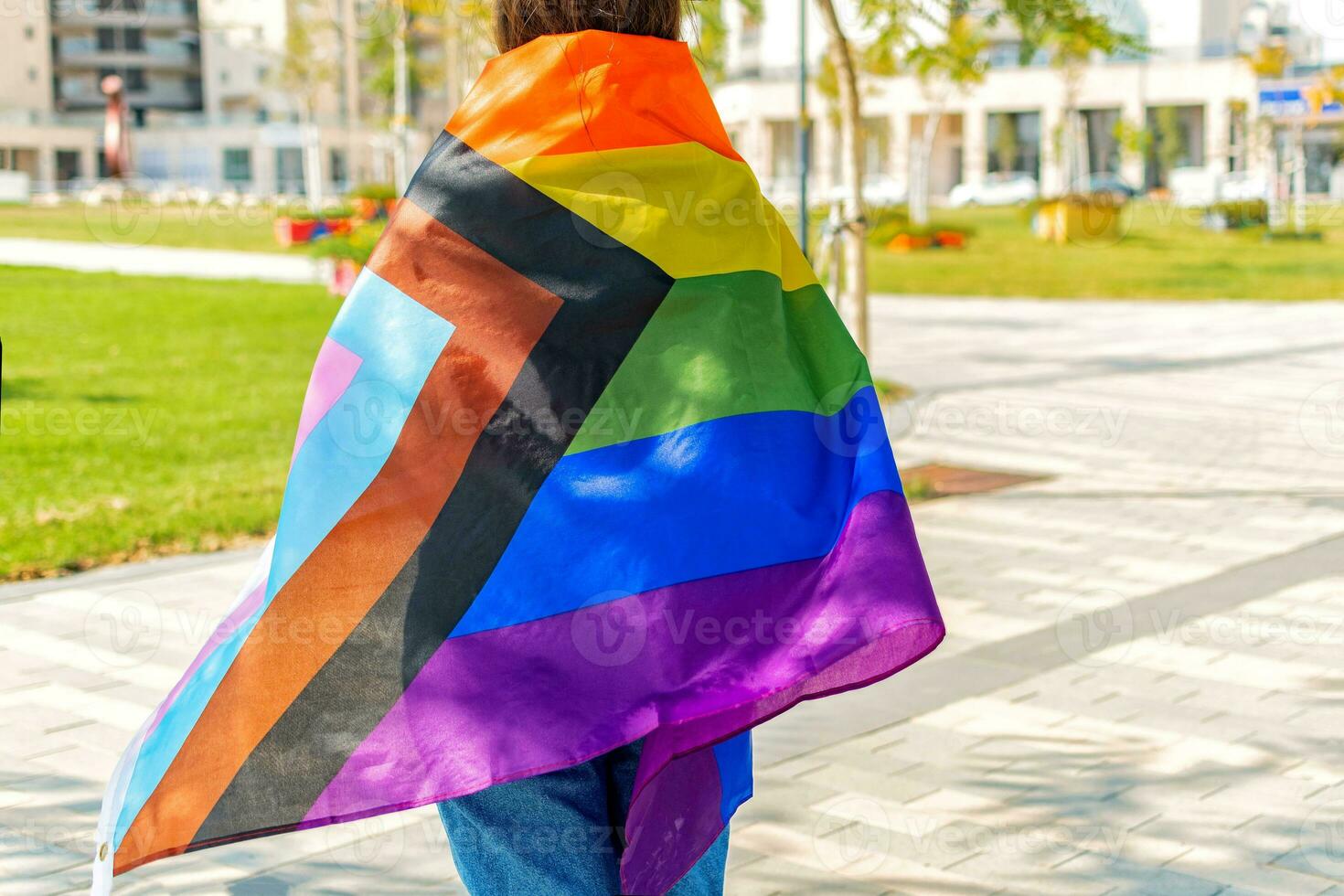 kvinna med de ny framsteg stolthet flagga på henne tillbaka. framsteg lgbtq regnbåge flagga. foto