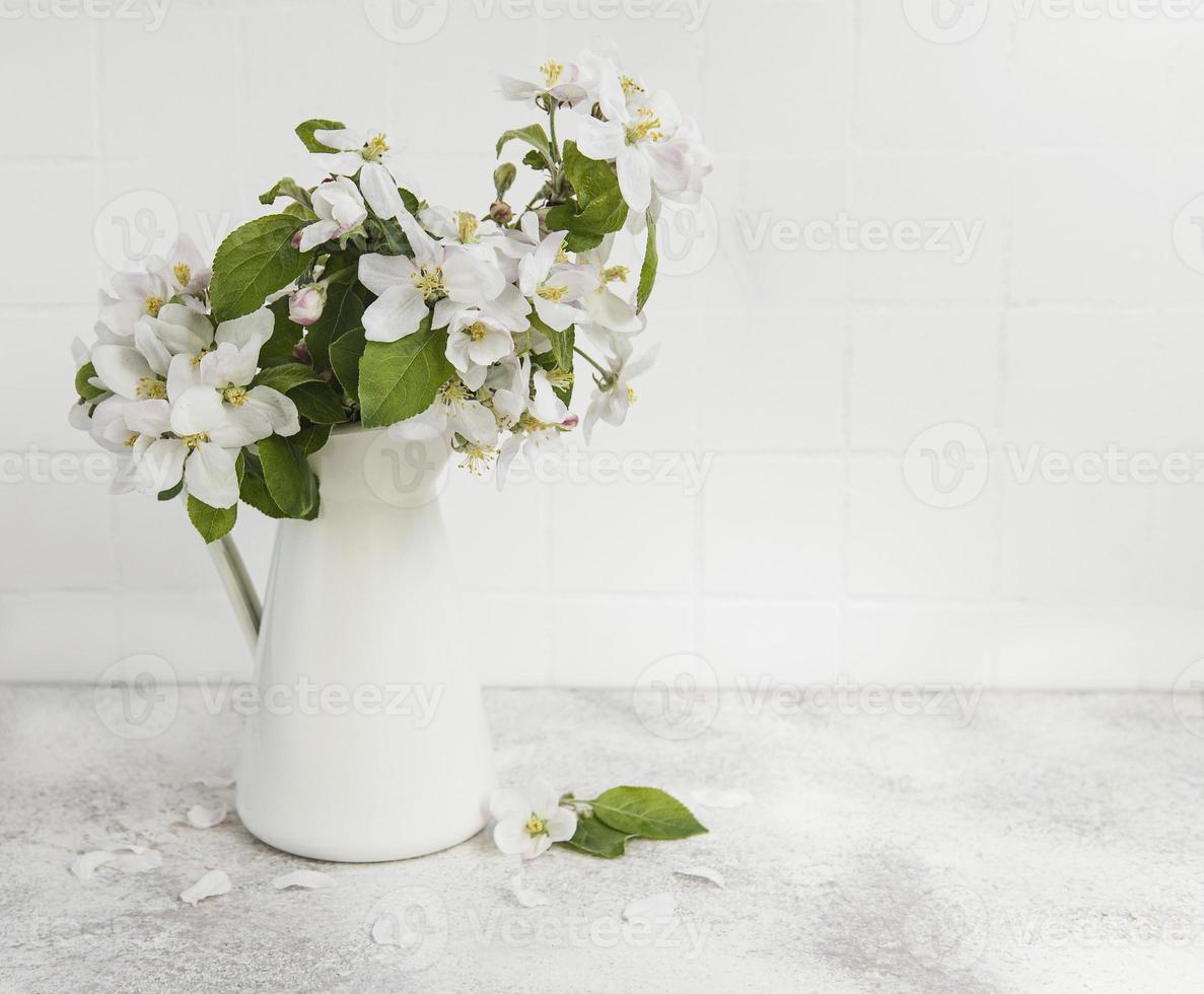 våräppleblom i en vit vas foto
