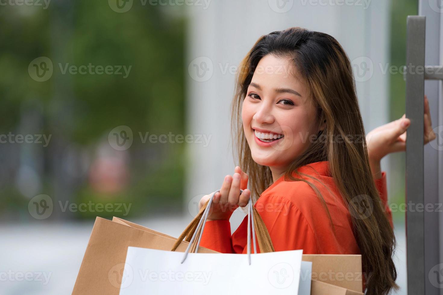 utomhus porträtt av glad kvinna med shoppingkassar foto
