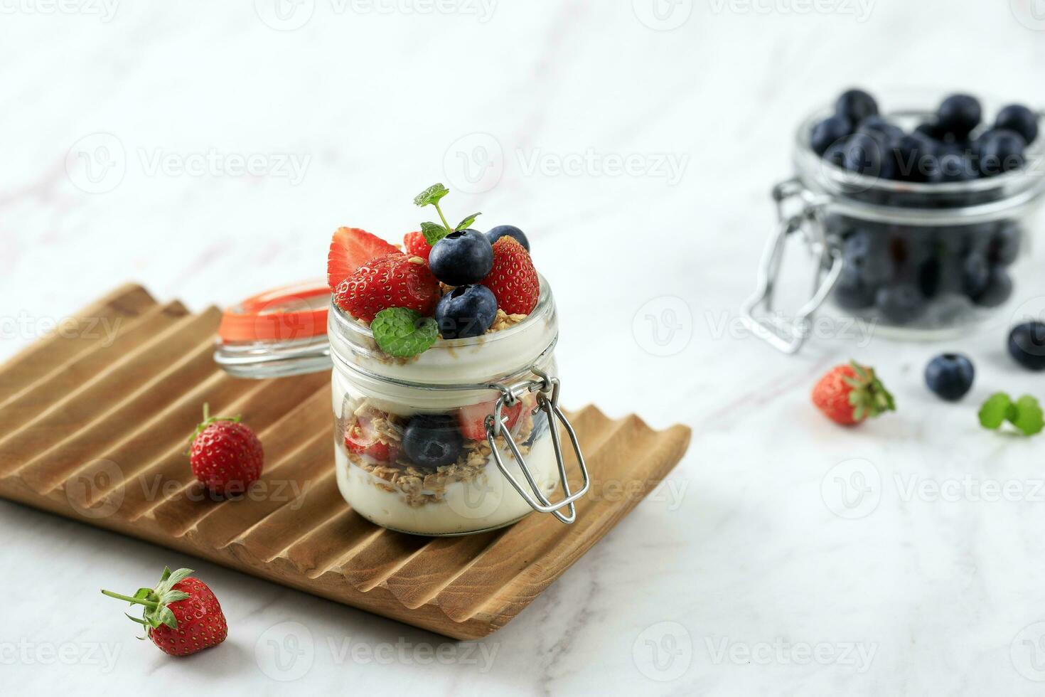 granola parfait, enkel yoghurt med färsk jordgubb och blåbär foto
