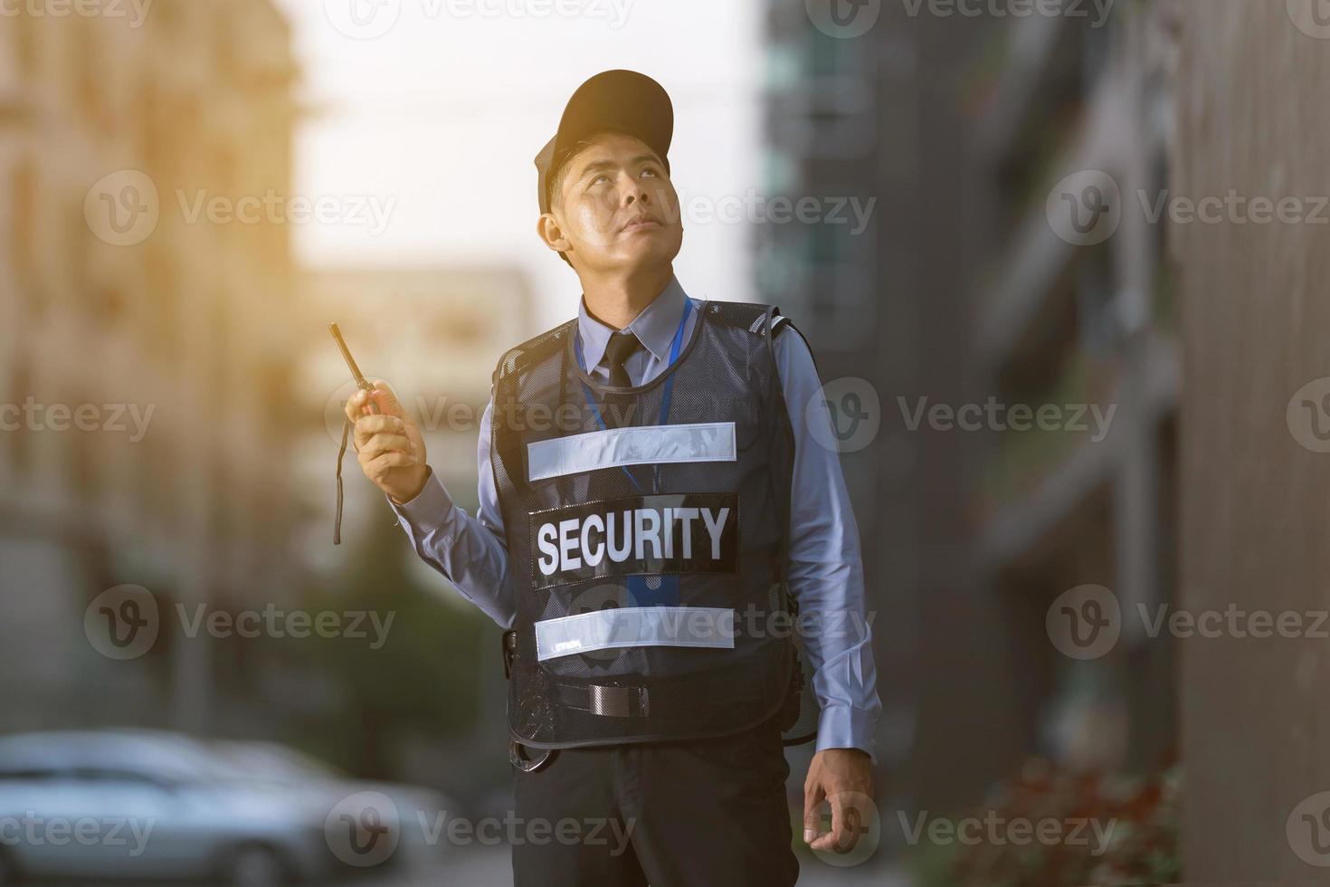 säkerhetsman som står utomhus med bärbar radio foto