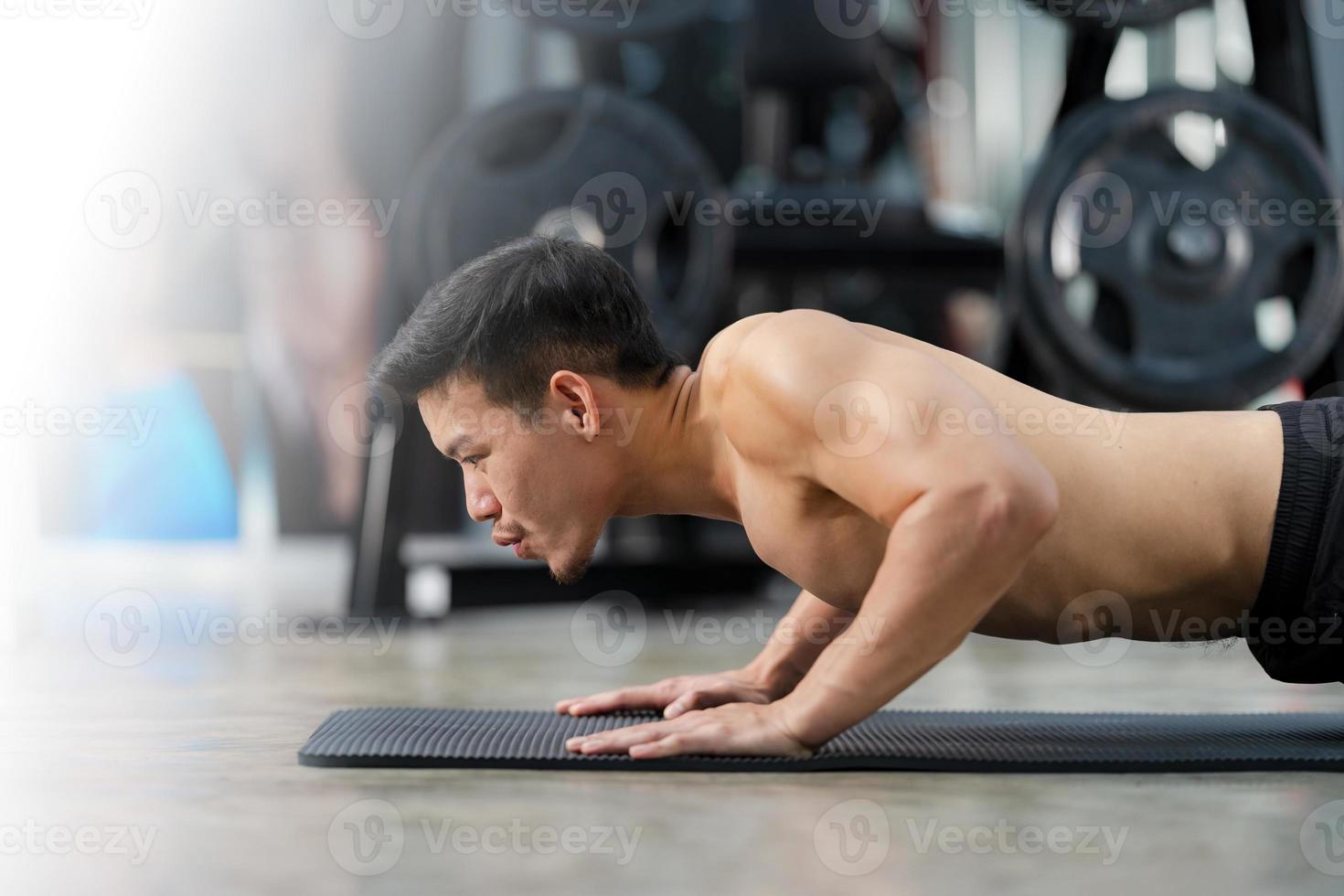 sportig man utbildning gör push ups på gymmet foto