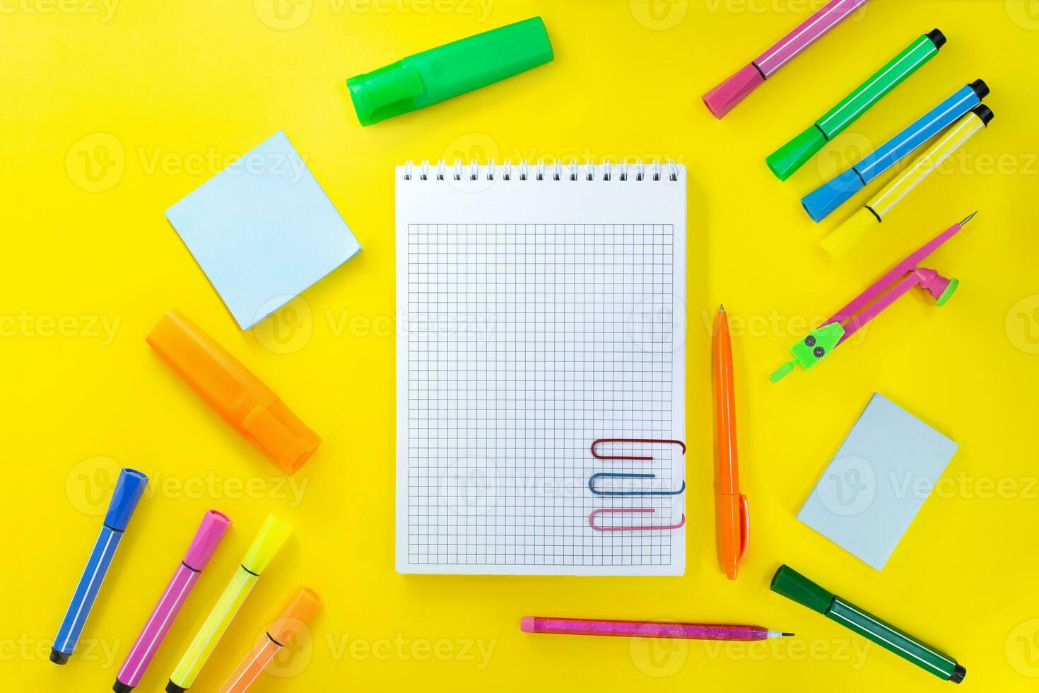 tillbaka till skola, teckning. anteckningsbok rutig med penna för anteckningar till text med papper clips. nära rosa, orange, grön pappersvaror. markörer, filt-tip pennor, klibbig notera, passare. begrepp av inlärning foto
