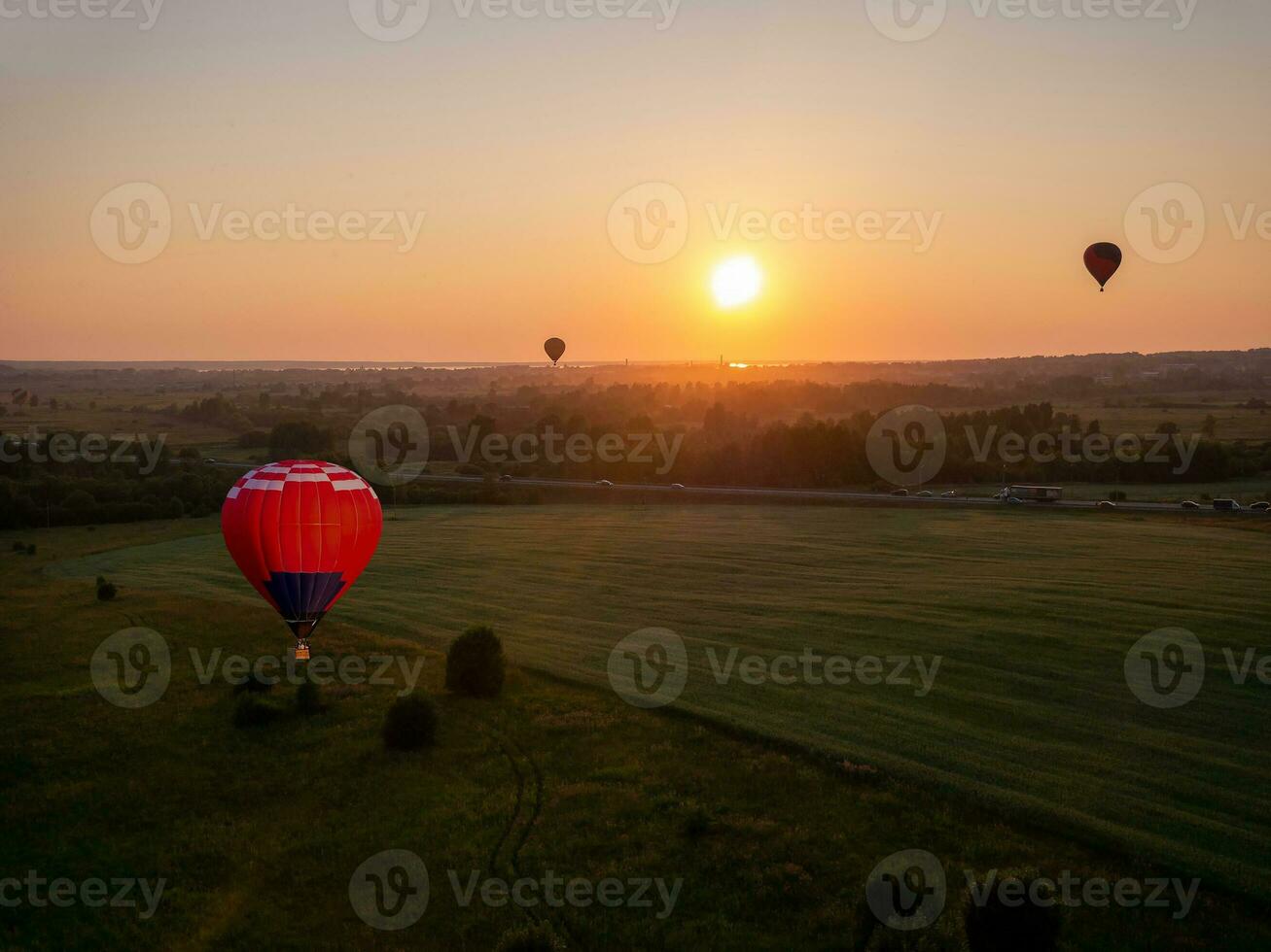 färgrik luft ballong är flygande i fri flyg över de fält. fågelöga se. flerfärgad ballong i de himmel på solnedgång foto