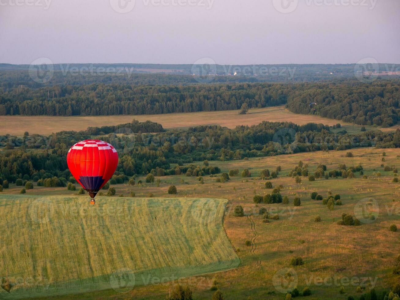 färgrik luft ballong är flygande i fri flyg över de fält. fågelöga se. flerfärgad ballong i de himmel på solnedgång foto