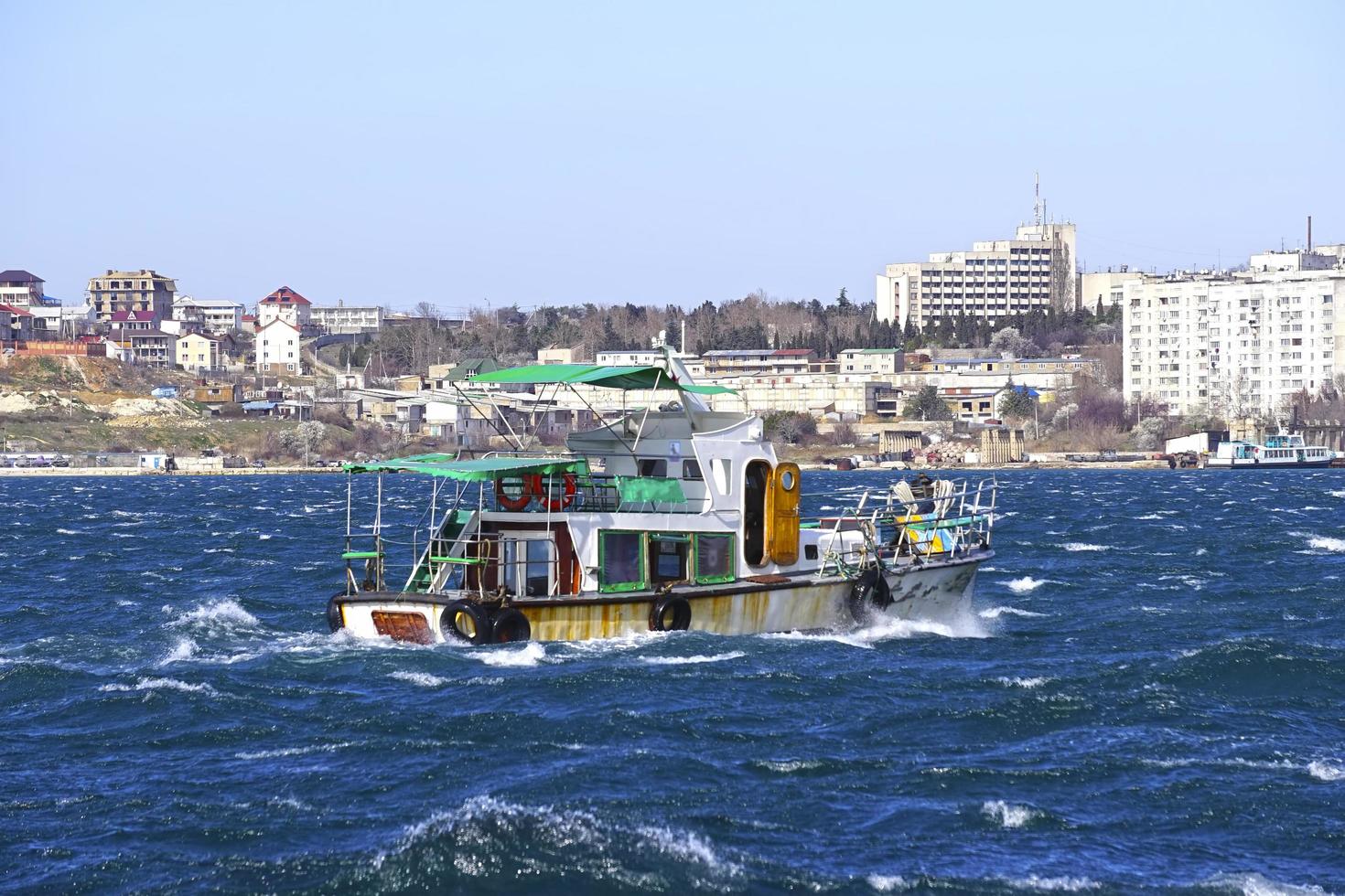 marinmålning med utsikt över båten på bakgrunden av staden sevastopol foto