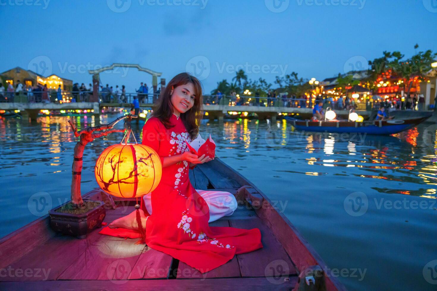 kvinna bär ao dai vietnamese klänning, resande sightseeing båt rida och flytande papper lykta på hoi ett gammal stad. landmärke för turist attraktioner.vietnam och sydöst resa begrepp foto