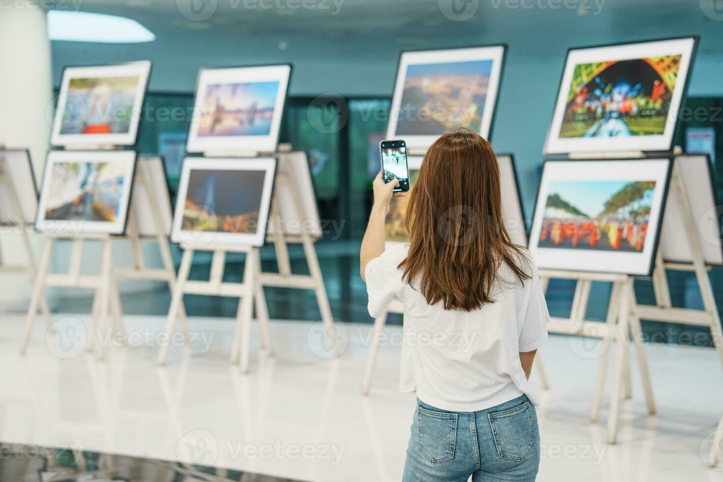 ung kvinna turist ser Galleri utställning. konst , fotografi och museum begrepp foto