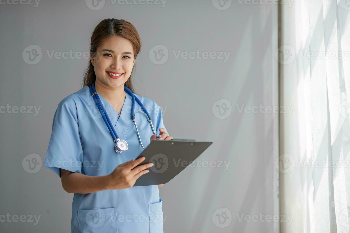 porträtt av kvinna asiatisk läkare stående i henne kontor på klinik. foto
