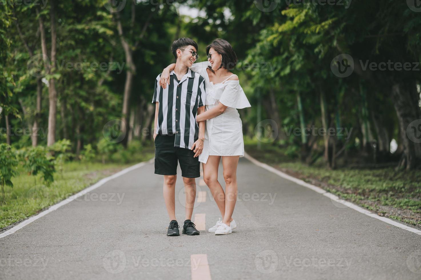 glada asiatiska gbt lesbiska par i kärlek har en bra tid står och kramar i parken foto