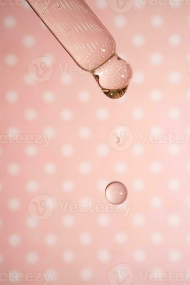 en droppande pipett med en släppa av kosmetika gel. foto
