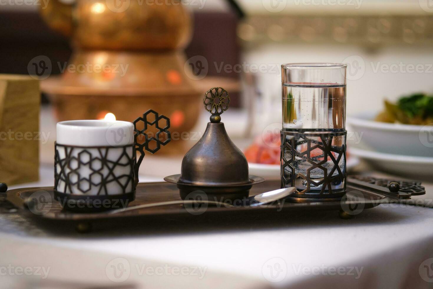 vatten, espresso och en socker behållare på en turkisk stil bricka. foto