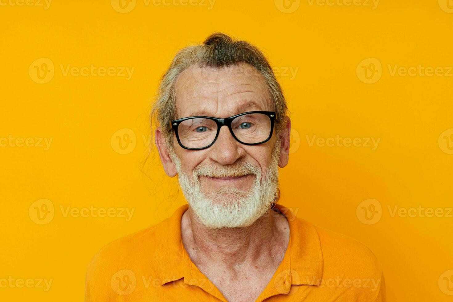 glad gammal man grå skägg glasögon gul bakgrund foto