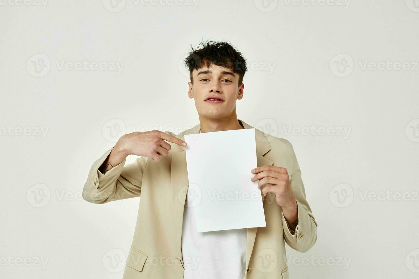 en ung man i en beige kostym copy-space mapp med papper ljus bakgrund oförändrad foto