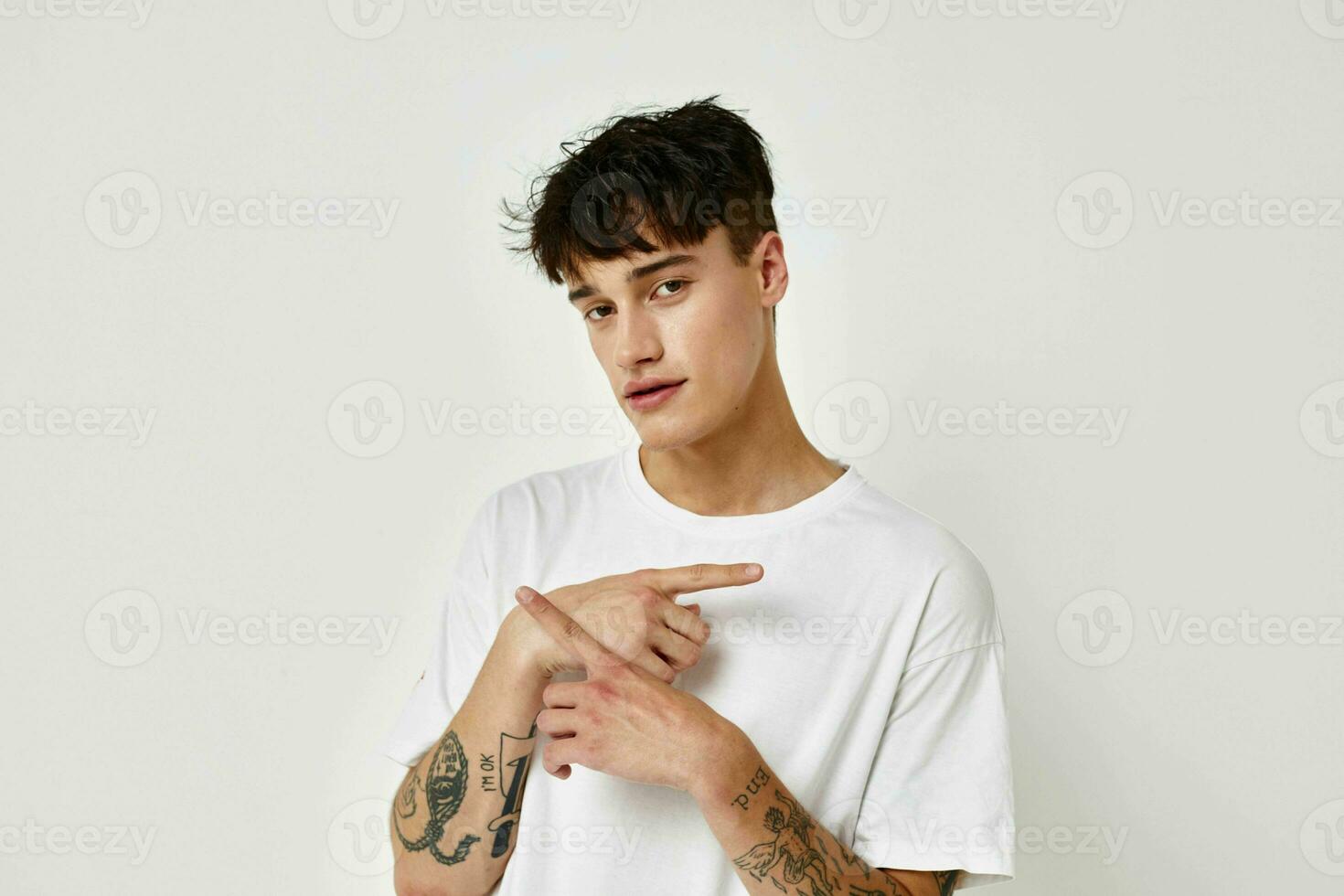 stilig kille modern ungdom stil vit t-shirt tatuering på de ärm modell studio foto