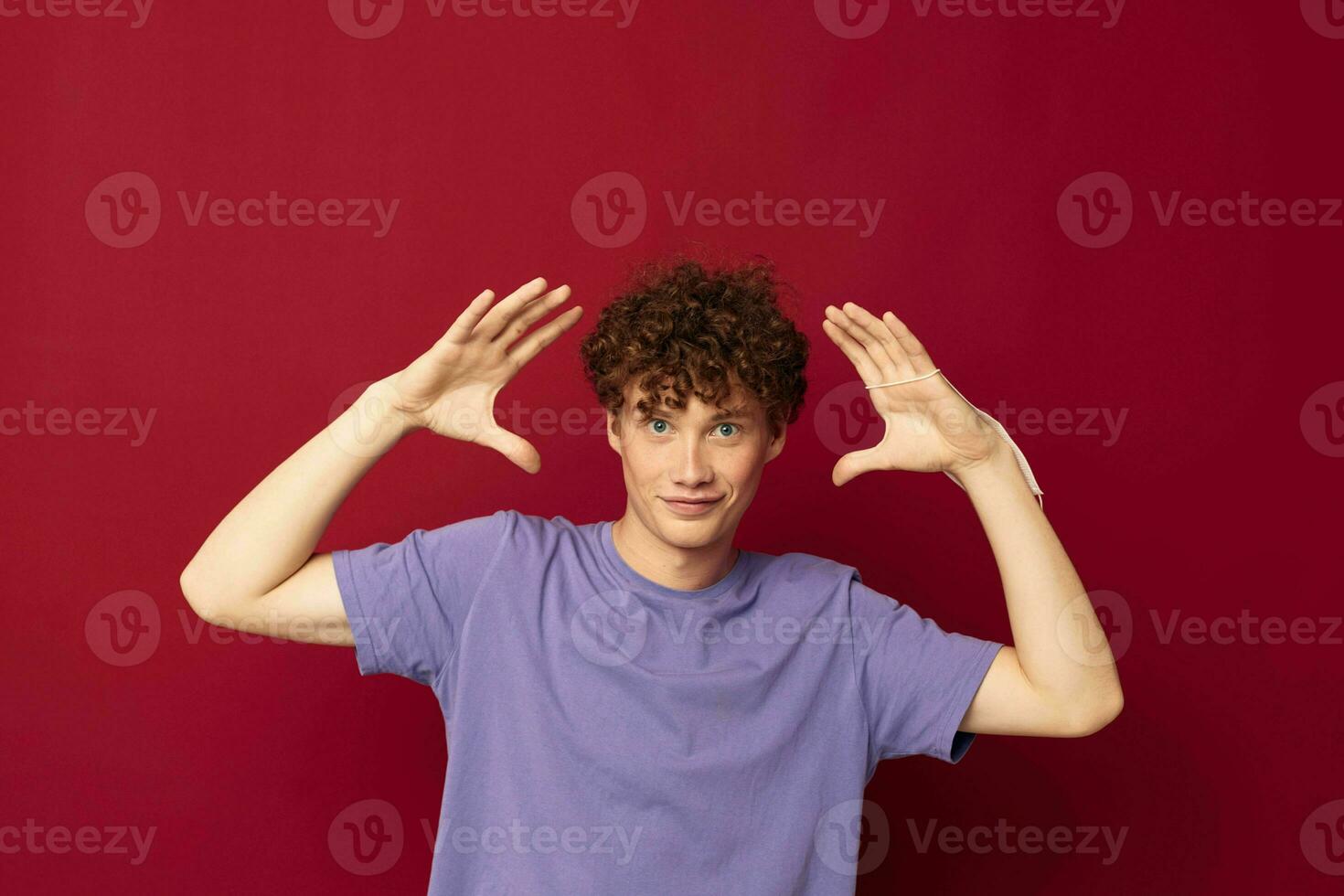 rödhårig kille med lockigt hår Framställ gest med händer foto