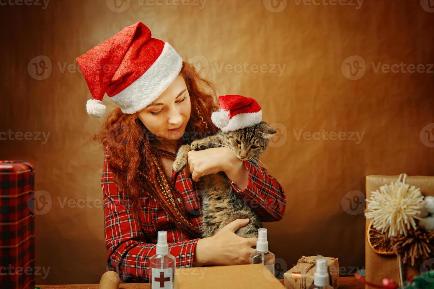 kvinna i jultomten hatt med katt i jul hatt foto
