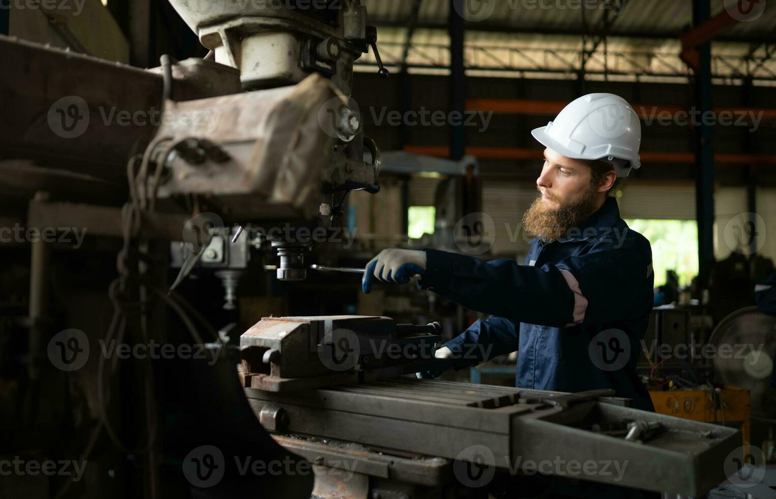 porträtt av mekanisk ingenjörer är kontroll de arbetssätt tillstånd av ett gammal maskin den där har varit Begagnade för några tid. i en fabrik var naturlig ljus lyser till de arbetsplats foto