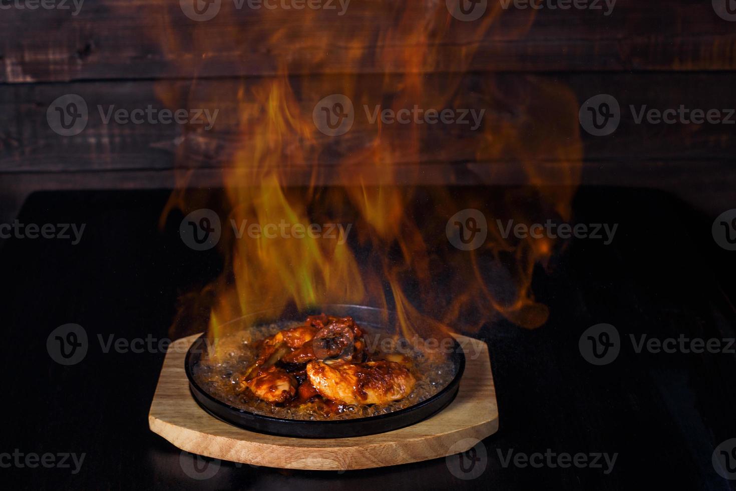 fajitos, kött i en stekpanna med eld på en träbricka, härlig servering, mörk bakgrund foto