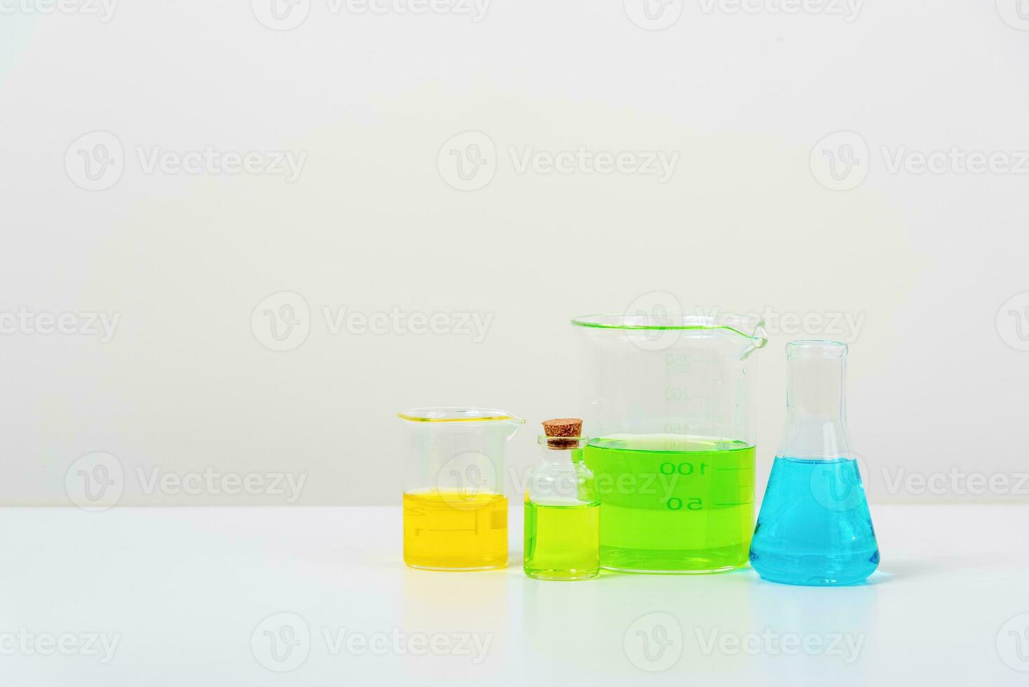 några testa rör på de vit tabell med bägare, flaskor, och testa rör fylld med färgrik vätskor foto