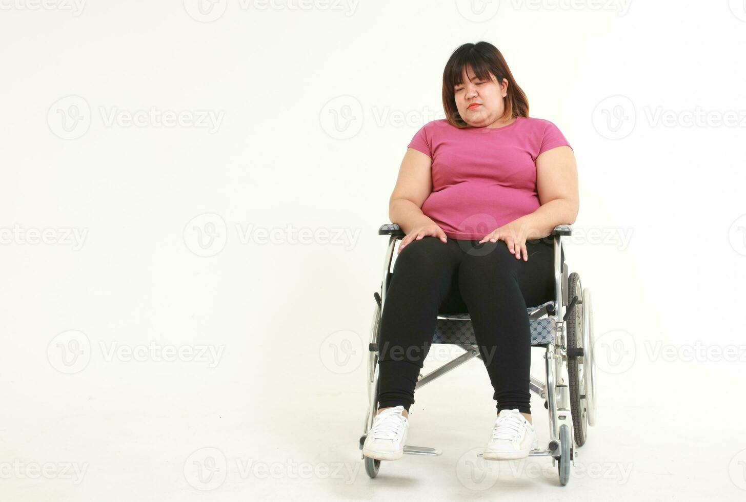 fett asiatisk kvinna lider från övning skador hon var Sammanträde i en rullstol. vikt förlust övning begrepp. hälsa försäkring. vit bakgrund. kopia Plats foto