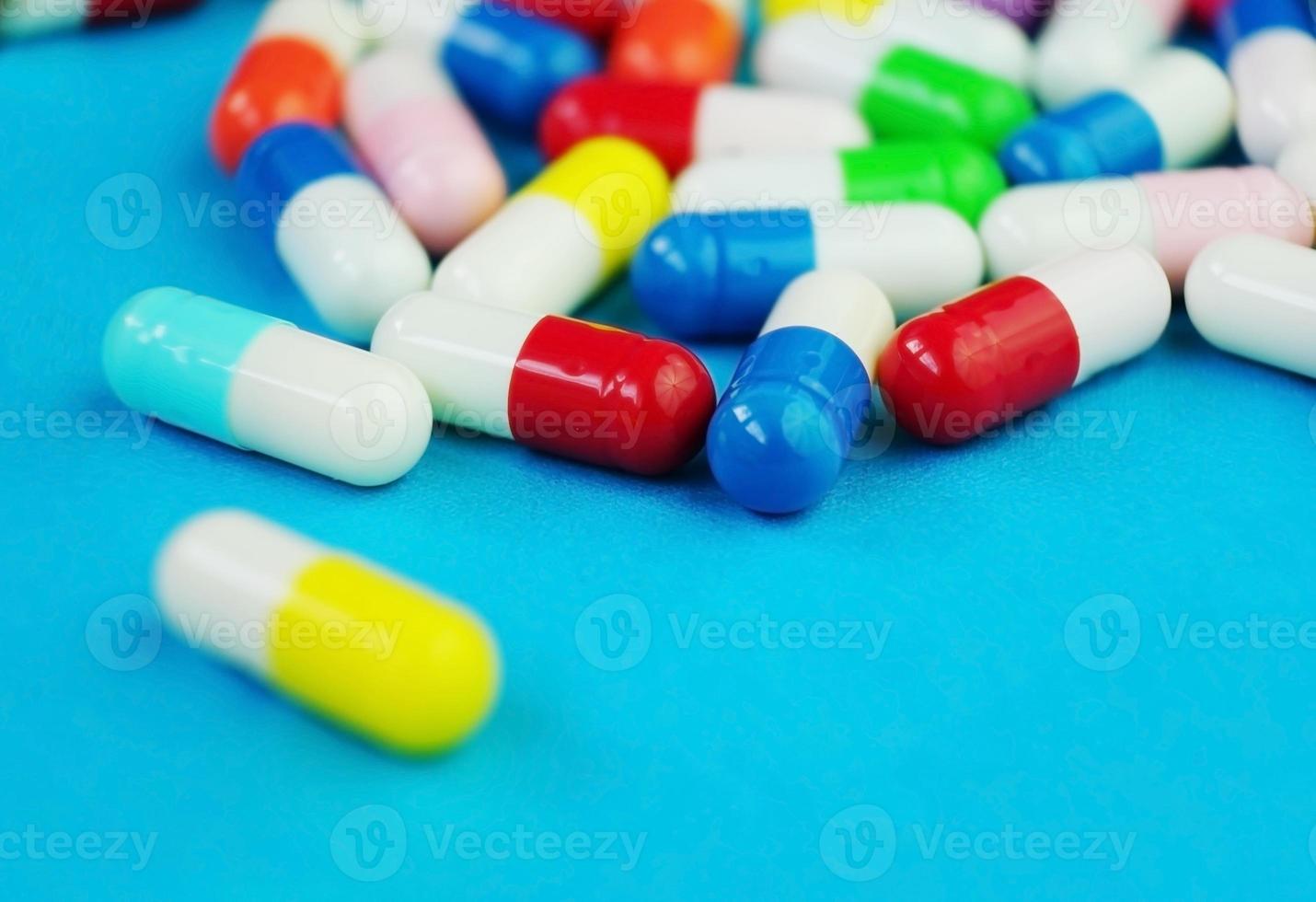 ett detaljerat makro av piller och kapslar med blå bakgrund foto