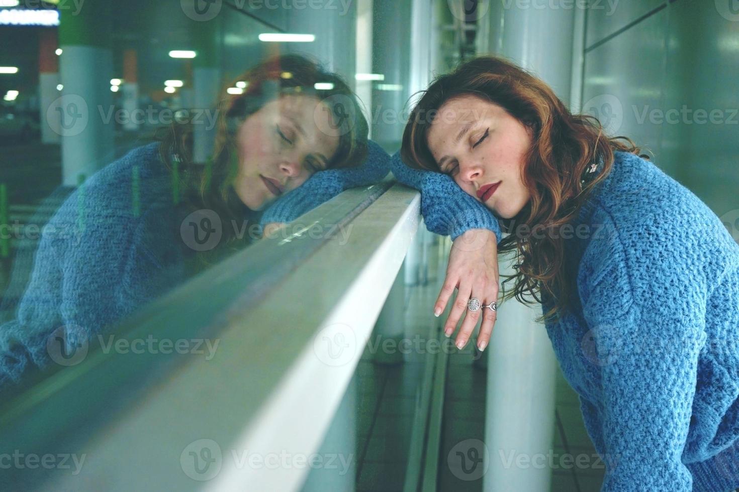 ung kvinna ensam och trött på en busstation foto