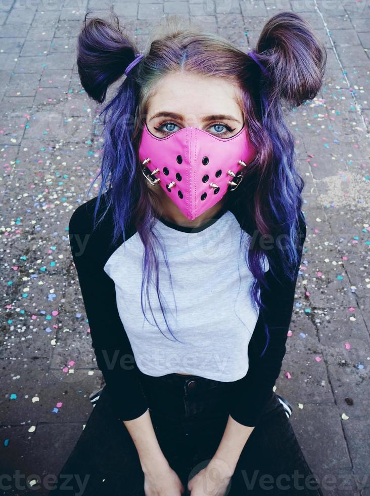 ung punk kvinna som bär en rosa mask foto