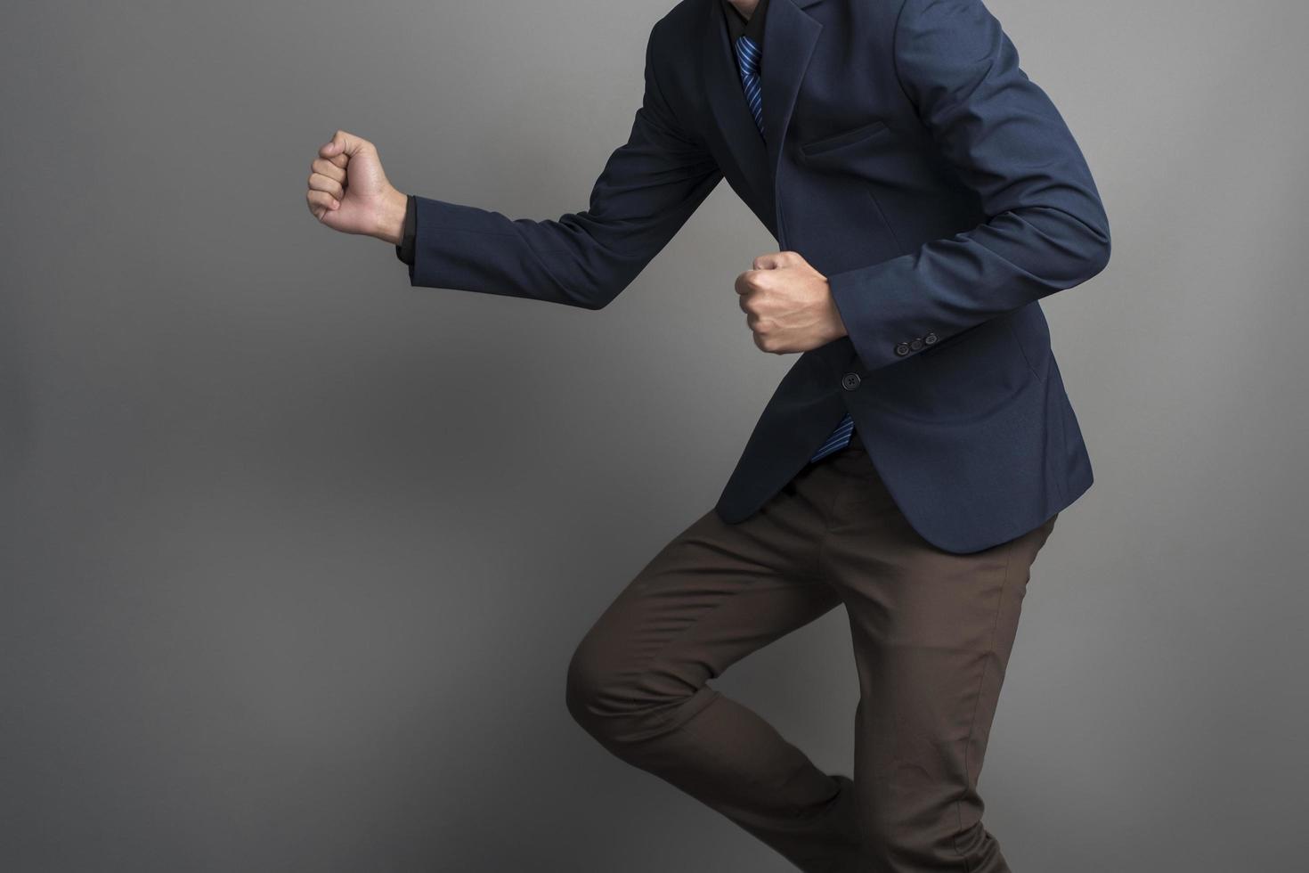 närbild av affärsman i blå kostym slåss på grå bakgrund foto
