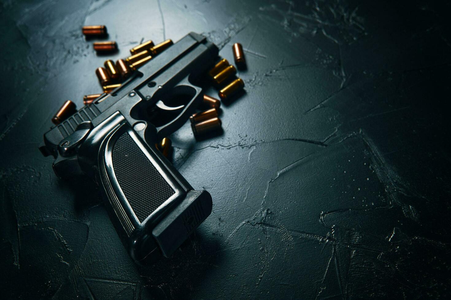 pistol med patroner på mörkt betongbord. foto