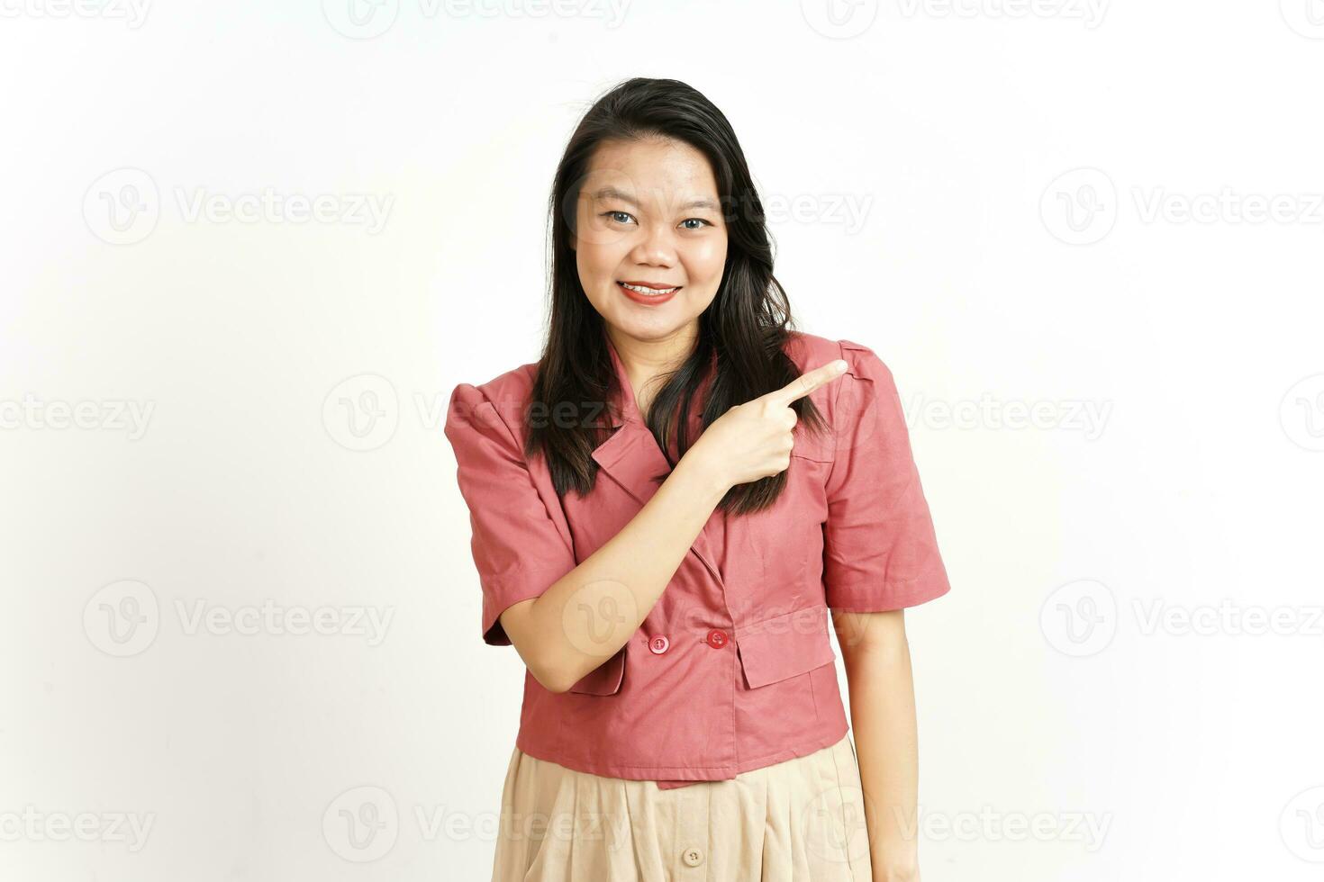 som visar produkt och pekande sida använder sig av pekfinger av skön asiatisk kvinna isolerat på vit foto