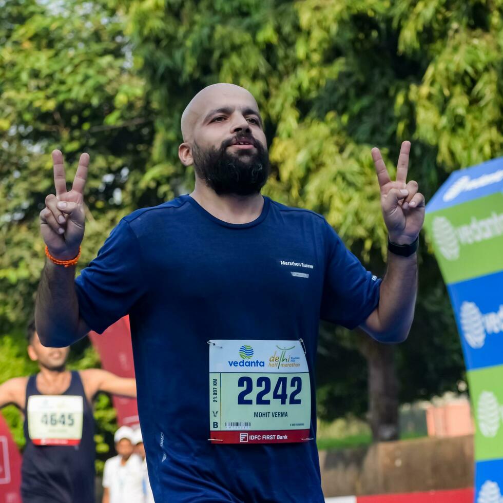 ny delhi, Indien - oktober 16 2022 - vedanta delhi halv maraton lopp efter covid i som maraton deltagarna handla om till korsa de Avsluta linje, delhi halv maraton 2022 foto