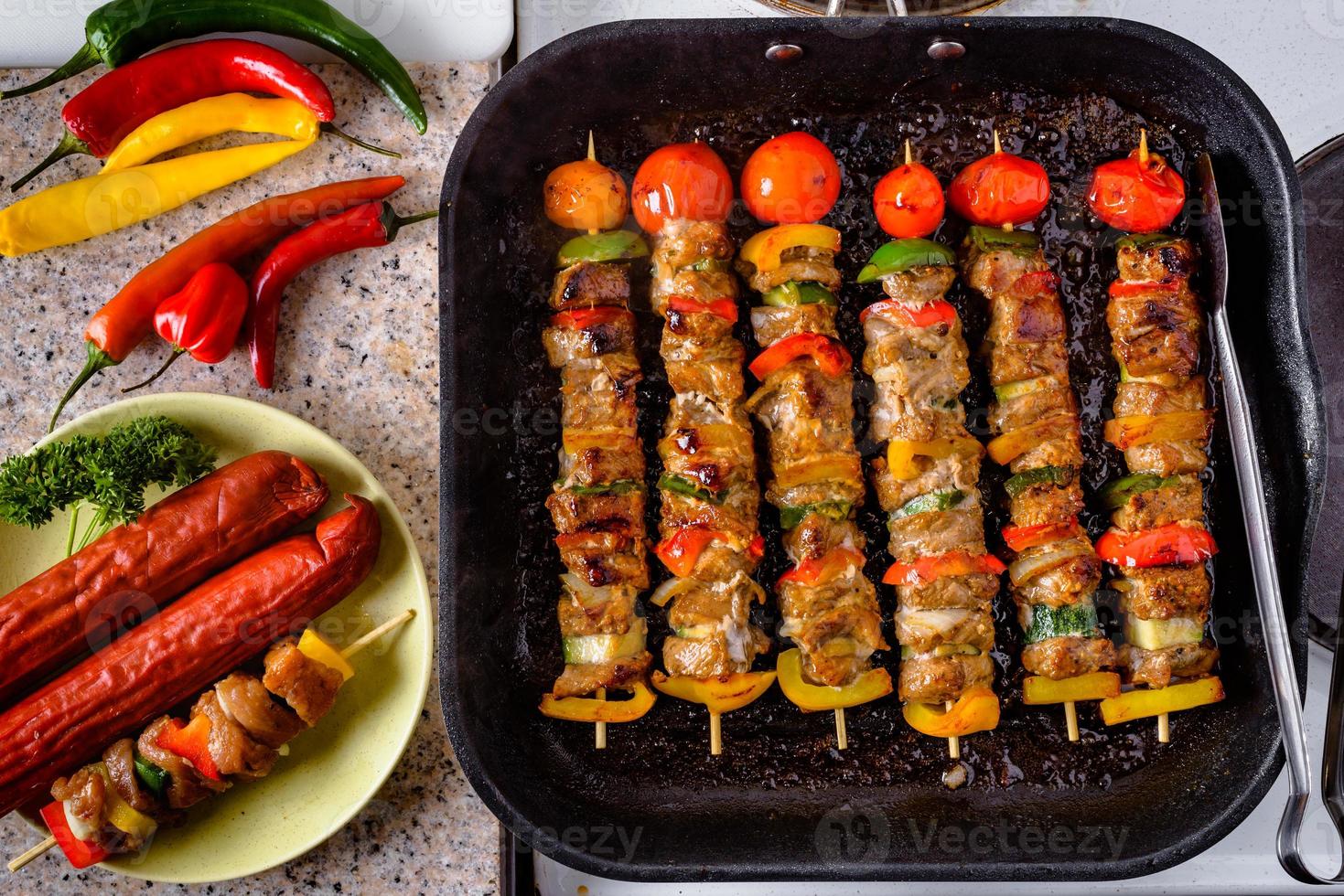 grillade grillspett på träpinnar, fläskkött och grönsaker på grillen. foto