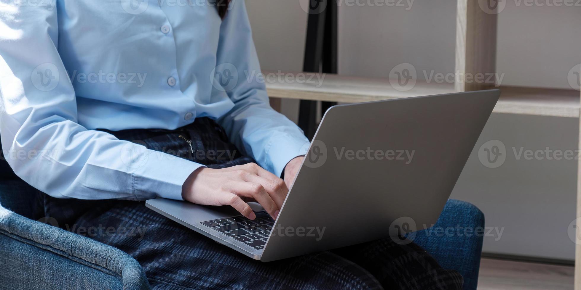 kvinna som använder bärbar dator i en loftstudio, student som forskar om bearbetningsarbete foto