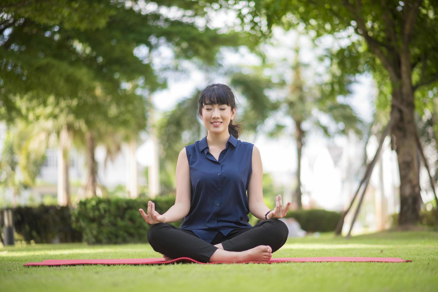 vacker yogakvinna på grön park foto