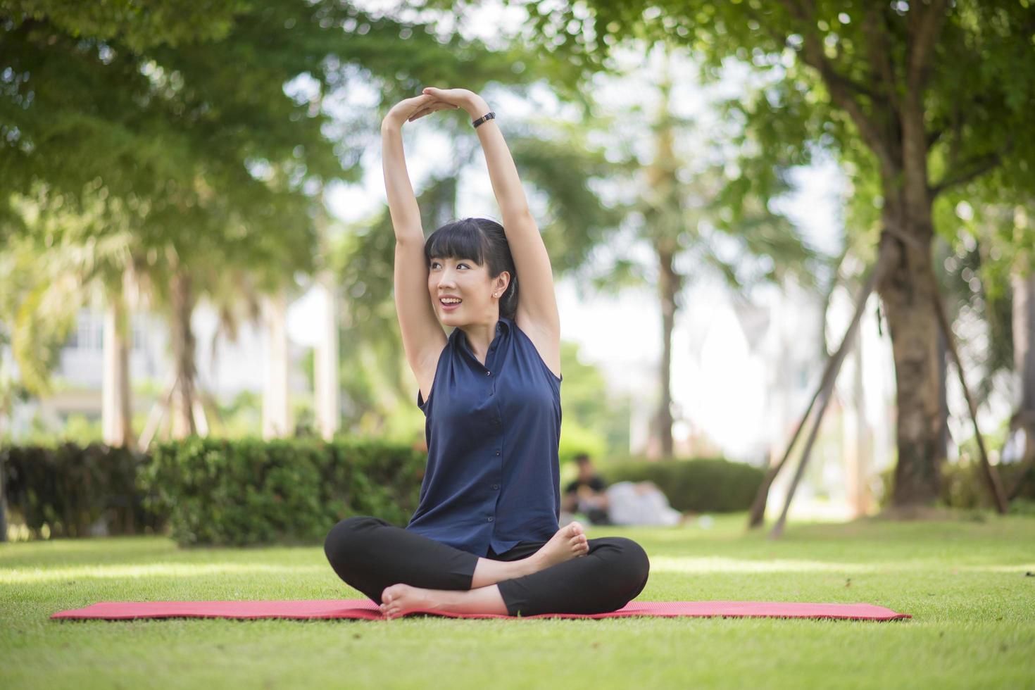 vacker yogakvinna på grön park foto