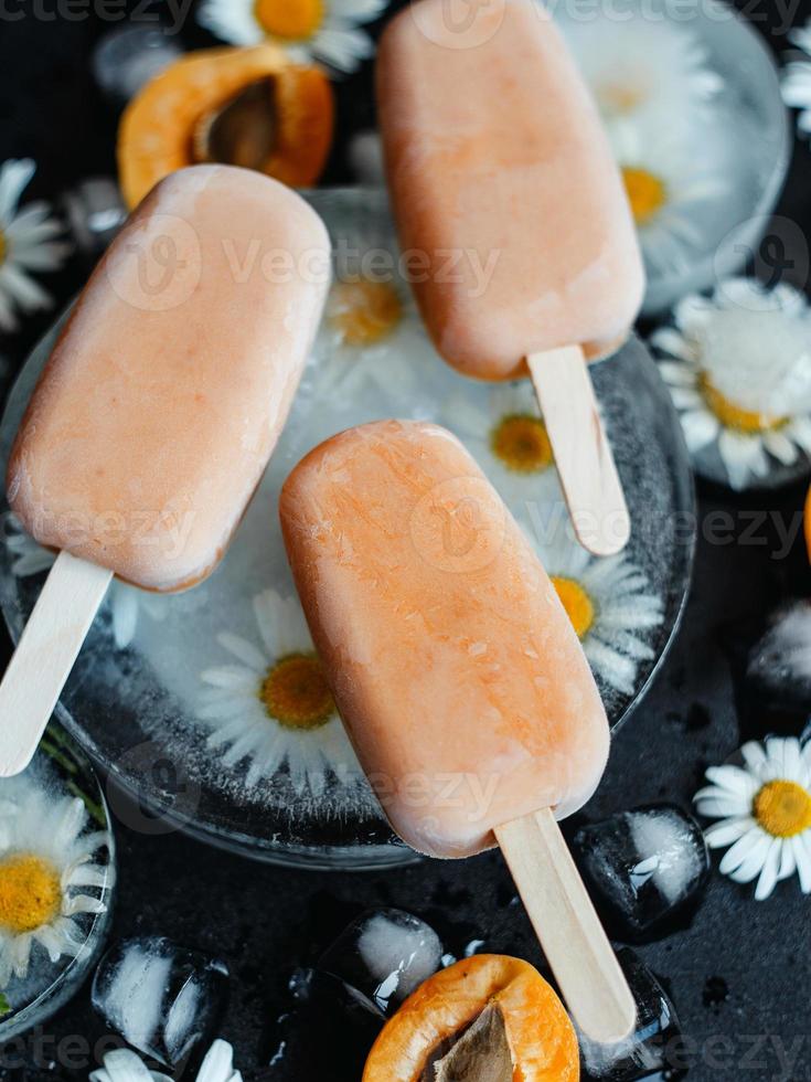 hemlagad glass på en pinne med aprikoser och yoghurt. hälsosam kost koncept foto