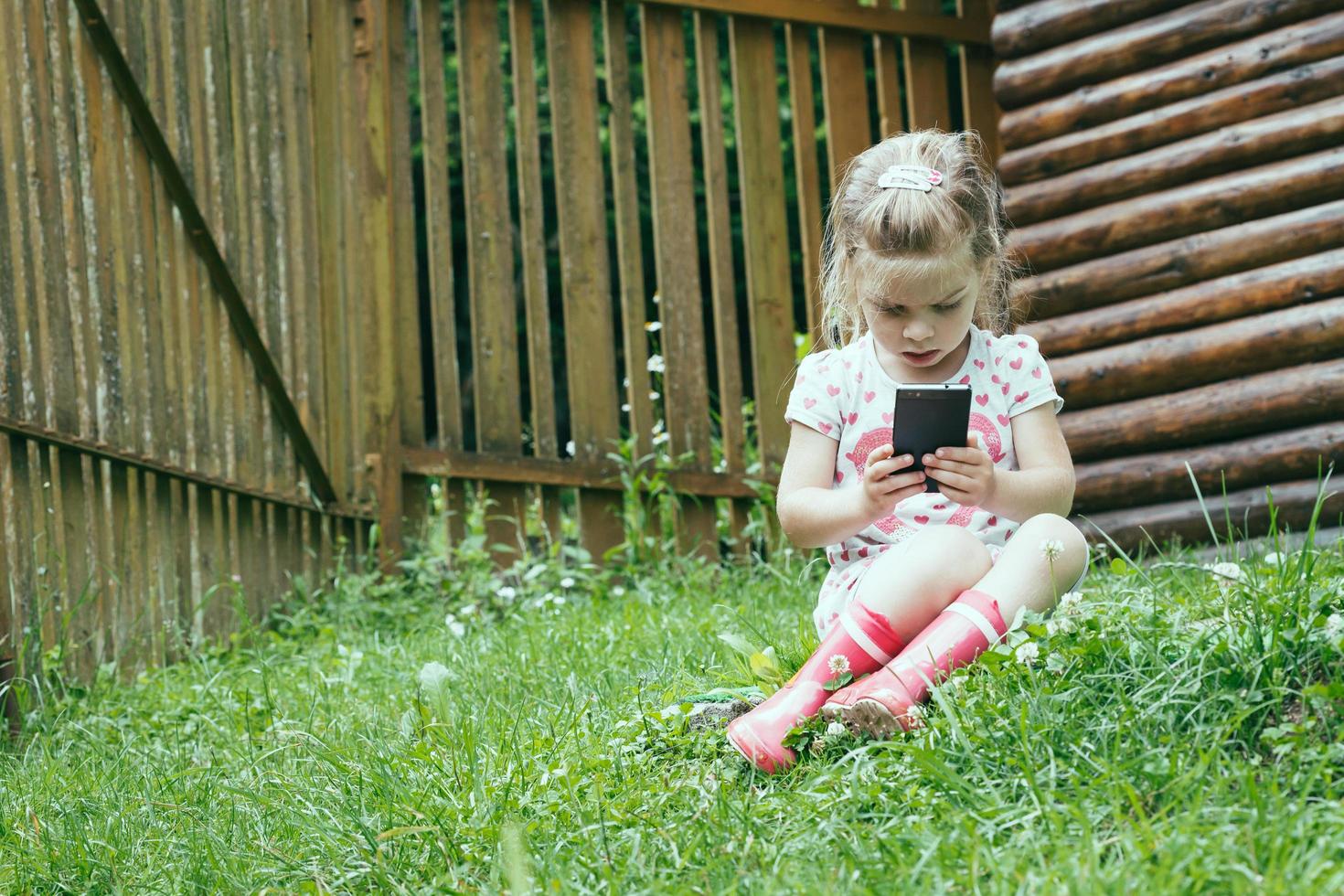 ung förskolebarn som använder smartphonebarn som använder digital teknik foto