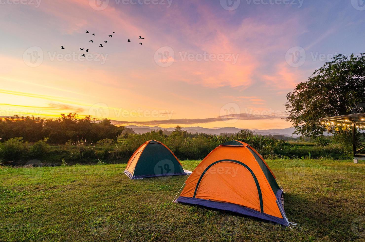 resa för att sprida tältet i ett öppet utrymme på kvällen. utsikt över den gyllene himlen berg på nakhasat sabai i Chiang Mai Thailand foto