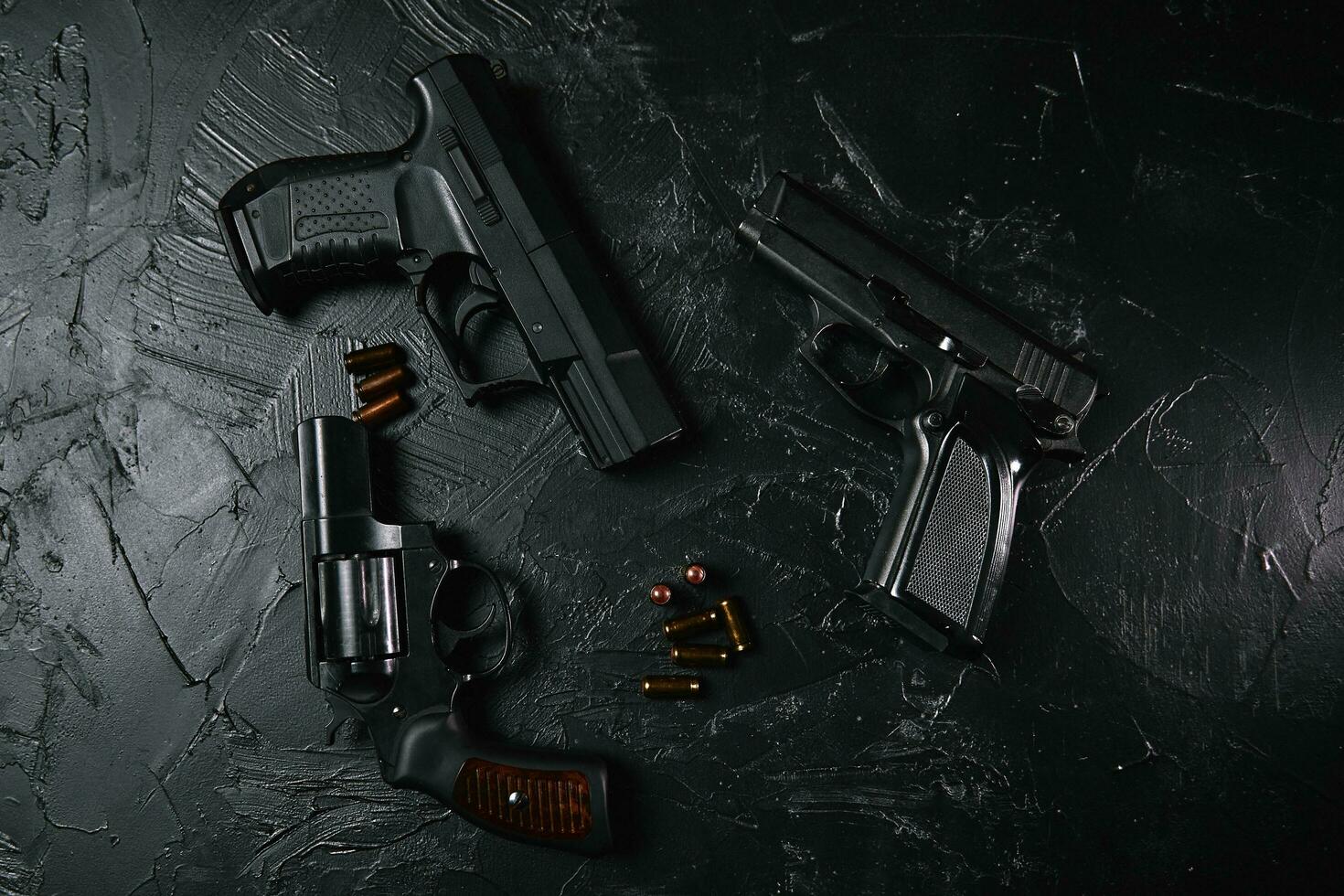 tre vapen och kulor på svart bord. foto