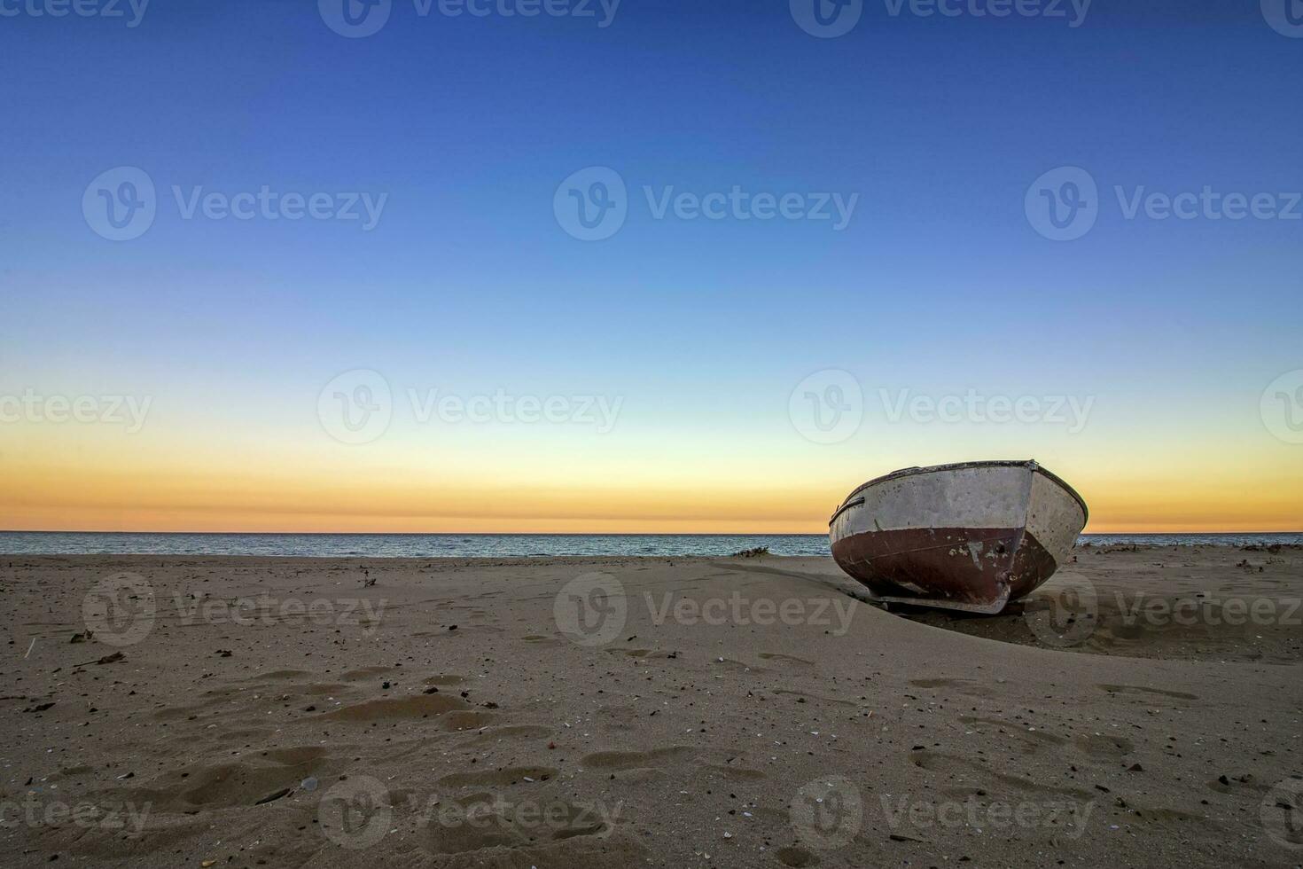 ensam gammal båt på de strand på solnedgång. horisontell se foto