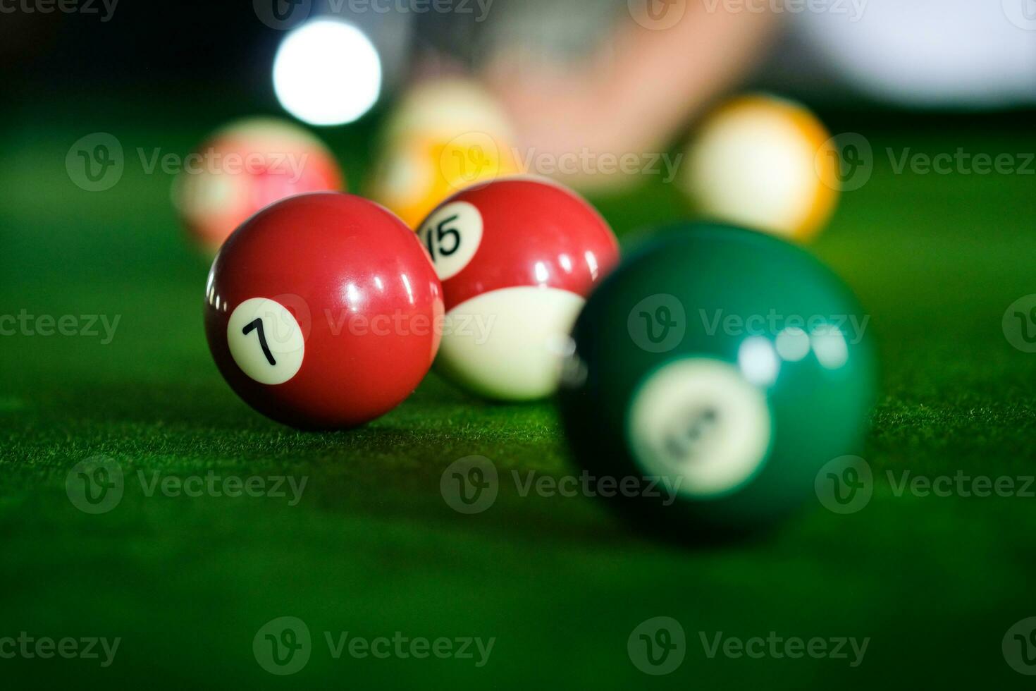 mannens hand och kö ärm spelar snooker spel eller framställning siktar till skjuta slå samman bollar på en grön biljard tabell. färgrik snooker bollar på grön fris. foto