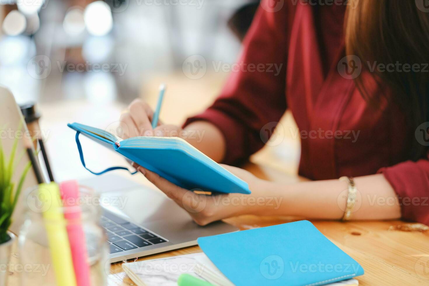 stänga upp kvinna händer med penna skrivning på anteckningsbok. foto