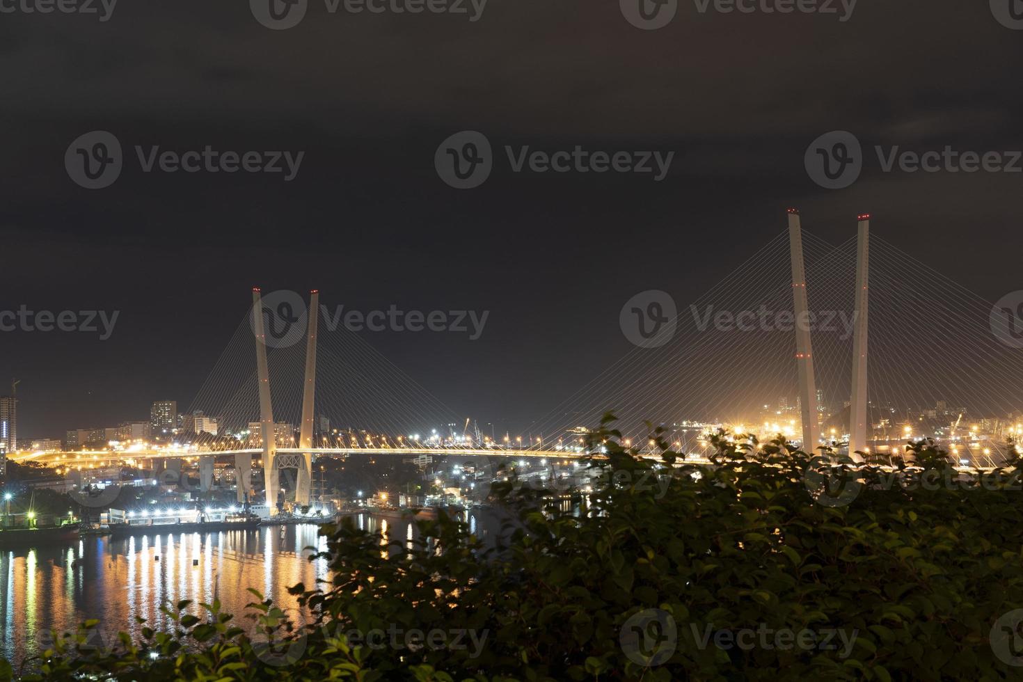 natt stadslandskap med utsikt över den gyllene bron Vladivostok foto